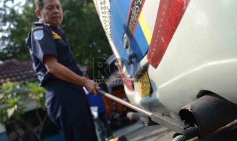  Petugas unit pengujian keliling Dinas Perhubungan DKI Jakarta melakukan uji emisi dan memeriksa komponen bus angkutan lebaran di Terminal Lebak Bulus, Jakarta, Kamis (1/8).    (Republika/Agung Supriyanto)