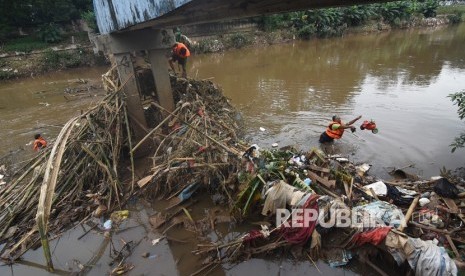 Petugas UPK Badan Air Dinas Lingkungan Hidup DKI Jakarta membersihkan sampah yang tersangkut di aliran Kanal Banjir Barat Ciliwung, Jakarta, Rabu (8/1/2020). 