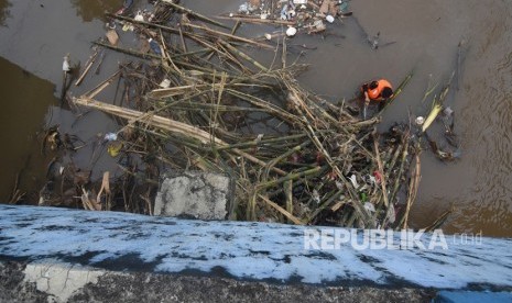 Petugas UPK Badan Air Dinas Lingkungan Hidup DKI Jakarta membersihkan sampah yang tersangkut di aliran Kanal Banjir Barat Ciliwung, Jakarta, Rabu (8/1/2020). 