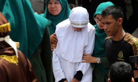 Petugas Wilayatul Hisbah (polisi syariat islam) membawa terpidana pelanggar peraturan daerah (qanun) Syariat Islam menuju panggung eksekusi untuk menjalani hukuman cambuk di halaman Masjid Rukoh, Kecamatan Syiah Kuala, Banda Aceh, Aceh, Selasa (1/3).