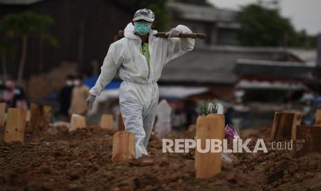 Petugas yang mengenakan APD bersiap memakamkan jenazah dengan protokol COVID-19 di TPU Tegal Alur, Jakarta, Selasa (29/12/2020). Pemprov DKI Jakarta menyiapkan lahan pemakaman di Rorotan sebagai antisipasi penuhnya TPU khusus COVID-19 di Pondok Ranggon dan Tegal Alur karena masih tingginya jumlah kematian akibat COVID-19.