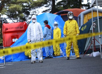 Petugas dengan pelindung lengkap bersiap mengecek tingkat radiasi di sekitar PLTN Fukushima