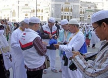 Petugas posko haji Telkomsel memberikan layanan di Masjidil Haram, Makkah