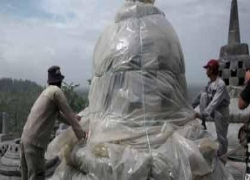 Petugas sedang memasang selubung plastik di stupa Borobudur