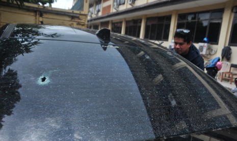 Pewarta mengambil gambar kondisi mobil yang menjadi barang bukti kasus penembakan mobil oleh polisi di Lubuk Linggau, di Mapolda Sumsel, Palembang, Jumat (21/4).