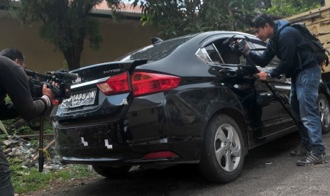 Pewarta mengambil gambar kondisi mobil yang menjadi barang bukti kasus penembakan mobil oleh polisi di Lubuk Linggau, di Mapolda Sumsel, Palembang, Jumat (21/4). 