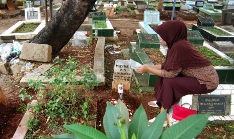 Peziarah berdoa di depan makam sanak saudaranya di kompleks pemakaman Pejaten Barat, Jakarta Selatan. Pengetatan PPKM mikro membuat Pemkot melarang kegiatan ziaran makam mulai Kamis  (24/6).