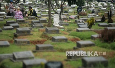  Peziarah berdoa di makam anggota keluarga (ilustrasi)