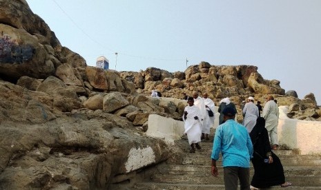 Peziarah mendaki Jabal Rahmah di Arafah, Makkah. Lokasi tersebut berada tepat di tengah wilayah wukuf Arafah.