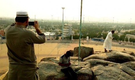 Peziarah mengambil gambar bentangan wilayah Namirah dan Lembah Uranah dari puncak Jabal Rahmah di Arafah, Makkah