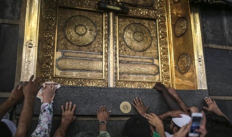  Jamaah haji berdoa saat mereka menyentuh Ka'bah, bangunan kubik di Masjidil Haram di kota suci Muslim, Mekkah, saat melakukan Tawwaf, gerakan anti-searah jarum jam di sekitar Ka'bah selama tahunan ziarah, yang dikenal sebagai haji, di Arab Saudi.