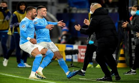 Phil Foden (C) merayakan golnya bersama pelatih Manchester City Pep Guardiola (R). Golnya membuat City unggul 2-1 pada leg kedua perempat final Liga Champions melawan Dortmund, Kamis (15/4).