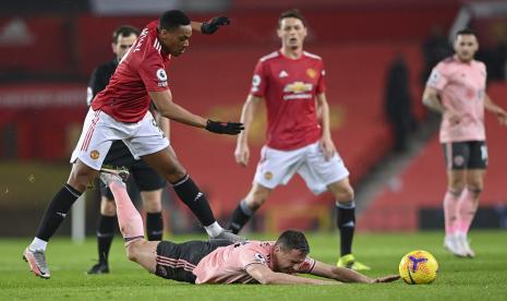  Phil Jagielka dari Sheffield United jatuh saat dia dilanggar oleh Anthony Martial dari Manchester United, kiri, selama pertandingan sepak bola Liga Premier Inggris antara Manchester United dan Sheffield United di Old Trafford, Manchester, Inggris, Rabu, 27 Januari 2021. 