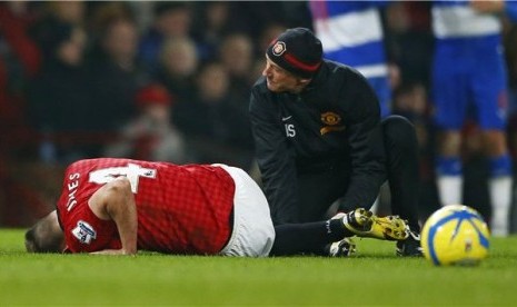 Phil Jones (kiri), pemain Manchester United, mendapat perawatan di lapangan saat menghadapi Reading di laga Piala FA di Old Trafford, Manchester, pada 18 Februari. 