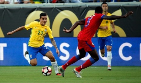 Philippe Coutinho (kiri) membawa bola coba melewati pemain Haiti. Coutinho mencetak hat-trick ke gawang Haiti pada lanjutan Copa America Centenario 2016.