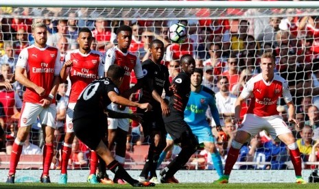 Philippe Coutinho saat mengambil tendangan bebas yang berbuah gol ke gawang Arsenal.