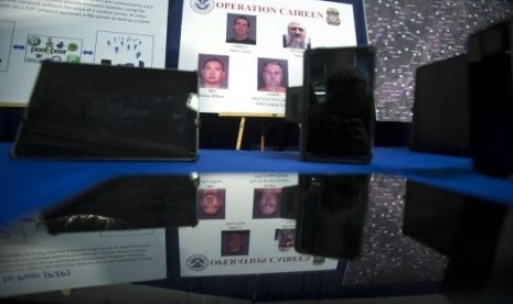 Photos of people arrested in a sting operation are reflected in a seized tablet computer following a news conference to announce the arrest of 71 individuals for sharing child pornography online in New York May 21, 2014.