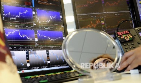  Pialang memantau pergerakan layar Indeks Harga Saham Gabungan di Global Market Bank Permata, Jakarta, Jumat (9\12).