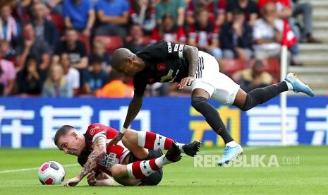 Pierre-Emile Hojbjerg (kiri) diganjal Ashley Young pada laga liga Inggris antara Southampton  melawan Manchester United   di Southampton,Sabtu (31/8) waktu setempat.