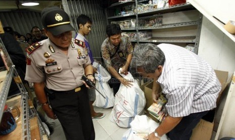 Pihak Kepolisian dan Tim Penyidik Ditjen Hak Kekayaan Intelektual (HKI) Kemenkum HAM menggerebek para pedagang DVD bajakan di Plaza Glodok,Jakarta Barat (1/2).