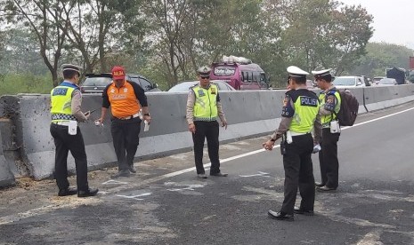 Pihak kepolisian sedang melakukan olah TKP kecelakaan beruntun di Tol Cipularang, Purwakarta, Selasa (3/9). 