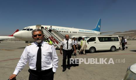  Pilot Ariana Afghan Airlines berjalan di landasan setelah mendarat di Bandara Internasional Hamid Karzai di Kabul, Afghanistan, Ahad (5/9). Beberapa penerbangan domestik telah dilanjutkan di bandara Kabul, dengan Ariana Afghan Airlines yang dikelola negara mengoperasikan penerbangan ke tiga provinsi. 