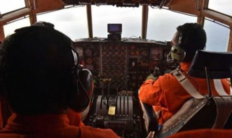 Pilot dan petugas di pesawat C-130 Hercules milik AU Indonesia sedang melakukan pencarian.