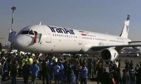 Pilot melambaikan bendera Iran setelah mendaratkan pesawat Airbus baru di Bandara Mehrabad, Teheran, Kamis (12/1). Pesawat tersebut dibeli Iran pertama dalam 40 tahun terakhir.