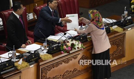 Pimpinan Dewan Perwakilan Rakyat (DPR), Utut Adiyanto (kedua kiri) dan Bambang Soesatyo (kiri) menerima tanggapan tertulis dari fraksi-fraksi DPR saat Rapat Paripurna Masa Persidangan I Tahun Sidang 2019-2020 di Kompleks Parlemen Senayan, Jakarta, Kamis (5/9/2019).