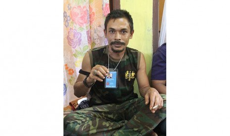 Pimpinan kelompok sipil bersenjata Nurdin alias Din Minimi memperlihatkan kartu jaminan keselamatan yang diberikan oleh United Nations Unies di Desa Ladang Baro, Kecamatan Julok, Aceh Timur, Aceh, Selasa (29/12).