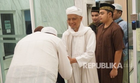 Pimpinan Majelis Azzikra KH Muhammad Arifin Ilham dengan didampingi putranya Muhammad Amer Azzikra (kedua kanan) dan Muhammad Alvin Faiz (ketiga kanan) menyalami jemaah ketika hendak meninggalkan Apartemen Mansion One di George Town, Penang, Senin (28/1/2019).