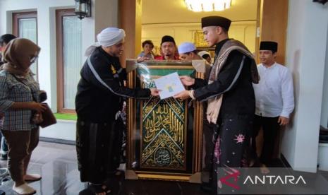 Pimpinan Majelis Talim Wal Maulid Ar Ridwan Habib Hussein bin Hasyim Baagil menitipkan kain penutup makam Rasul untuk Presiden Joko Widodo yang diserahkan kepada Ketua Umum PSI, Kaesang Pangarep di Kabupaten Tuban, Jawa Timur, Sabtu (2/12/2023).