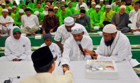 Pimpinan Yayasan Al Fatih Kaffah, Ustadz Fadlan Garamatan (kanan), membimbing Kepala Suku Asmat Papua, Umar Abdul Kayimter (dua kanan), membaca dua kalimat Syahadat dengan didampingi istri dan putranya di Masjid Darussalam, Jatibening, Bekasi, Jawa Barat, 