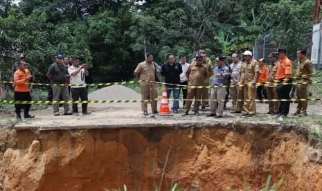 Pj Bupati Muba Drs Apriyadi MSi meninjau lokasi tampak tanah longsor tergerus hingga membentuk turunan tebing dan terpaksa di sekitar lokasi di tutup sementara