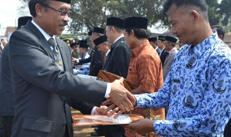  Pj. Bupati Pangandaran Daud Achmad (kiri) mengapresiasi sejumlah PNS dalam puncak peringatan Hari Jadi Kabupaten Pangandaran ke-3 di Pangandaran, belum lama ini. 