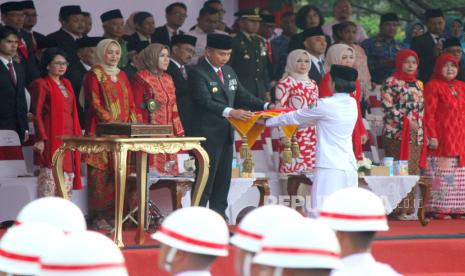 PJ Gubernur Jawa Barat Bey Machmudin memberikan bendera merah putih kepada Paskibraka saat Upacara Peringatan HUT Kemerdekaan RI ke-79, di Lapangan Gasibu, Kota Bandung, Sabtu (17/8/2024). Upacara yang diikuti oleh Forkopimda, pegawai pemerintah Provinsi Jawa Barat, TNI, Polri dan pelajar tersebut mengusung tema Nusantara Baru, Indonesia Maju.