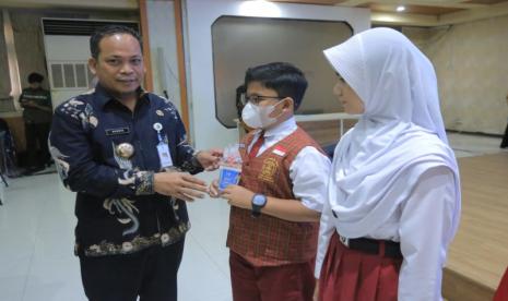 Pj Wali Kota Tangerang Nurdin memberikan plakat secara simbolis kepada seorang pelajar pada acara peluncuran program Pelajar Tangerang Menggaji yang dilangsungkan di Aula Al Amanah Gedung Puspem Kota Tangerang, Kamis (11/1/2024). 