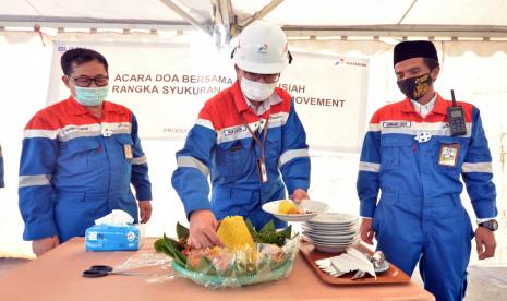 Pjs General Manager Pertamina RU VI Balongan Nur Qadim memotong tumpeng dalam acara syukuran dan doa bersama.