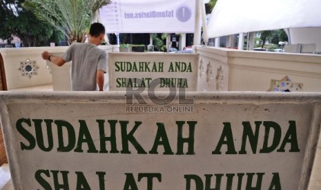 Plang ajakan Shalat dipasang pada pintu masuk didepan Masjid Husnul Khotimah, Jakarta Pusat, Rabu (21/1). (Republika/ Tahta Aidilla)