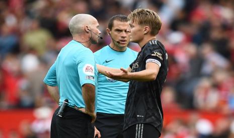 Playmaker Arsenal Martin Odegaard (kanan) berbicara dengan wasit Paul Tierney dalam pertandingan Manchester United vs Arsenal di Liga Primer Inggris,