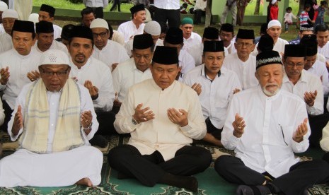 Plt Gubernur Aceh, Soedarmo (tengah) bersama Wali Nanggroe Aceh, Malik Mahmud (kanan) dan pejabat muspida Aceh, berdoa saat ziarah di kuburan massal korban tsunami Aceh di Desa Ulee Lheue, Banda Aceh, Senin (26/12).