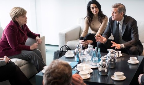 PM Jerman Angela Merkel tampak berbincang dengan aktor George Clooney dan istrinya Amal Alamuddin tentang pengungsi Suriah di Jerman.