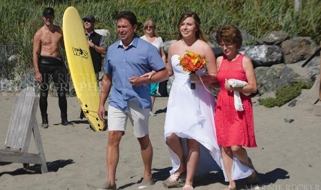 PM Kanada Justin Trudeau tampak memegang selancar dan berdiri di tepi memberi jalan bagi pengantin yang hendak menikah.