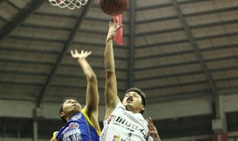 Point guard Aspac Andakara Prastawa Dhyaksa (kanan) berusaha memasukkan bola saat melawan Bandung Utama, Rabu (10/12).