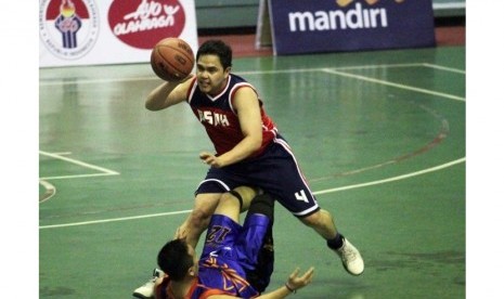 Point guard Berita Satu Media Holding Sofyan Syafril berusaha dihentikan pemain Kompas TV.