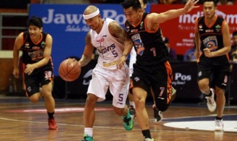 Point guard CLS Knight Mario Wuysang (bawa bola) saat menghadapi Satya Wacana di Seri II NBL Indonesia, Kamis (11/12).