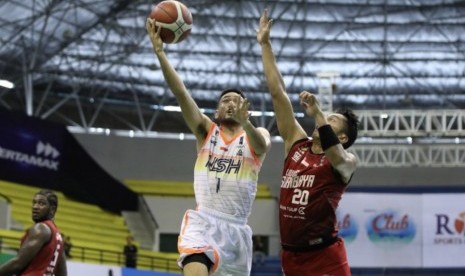 Point guard NSH Jakarta Widyanta Putra Teja memasukkan bola dijaga oleh guard Louvre Surabaya Wendha Wijaya.(DOk IBL)