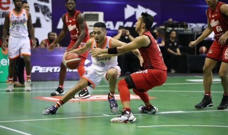 Point guard NSH Jakarta Widyanta Putra Teja membawa bola dijaga point guard Louvre Surabaya Wendha Wijaya.