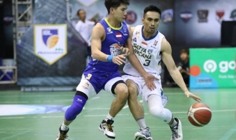 Point guard Satria Muda Pertamina Christian Gunawan menjaga point guard Satya Wacana Salatiga Cio Manuputty dalam pertandingan Seri IV IBL 2020.