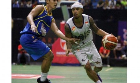 Point guard Satria Muda Pertamina Hardianus Lakudu (kir) menjaga point guardCLS Knights Mario Wuysang.